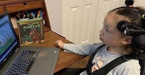girl looking at computer screen with head switch